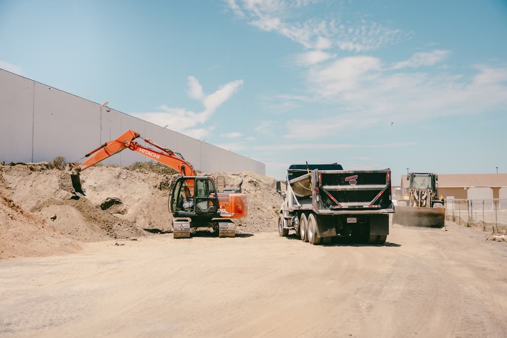 Excavator, dump truck and wheel loader working the piles at the yard